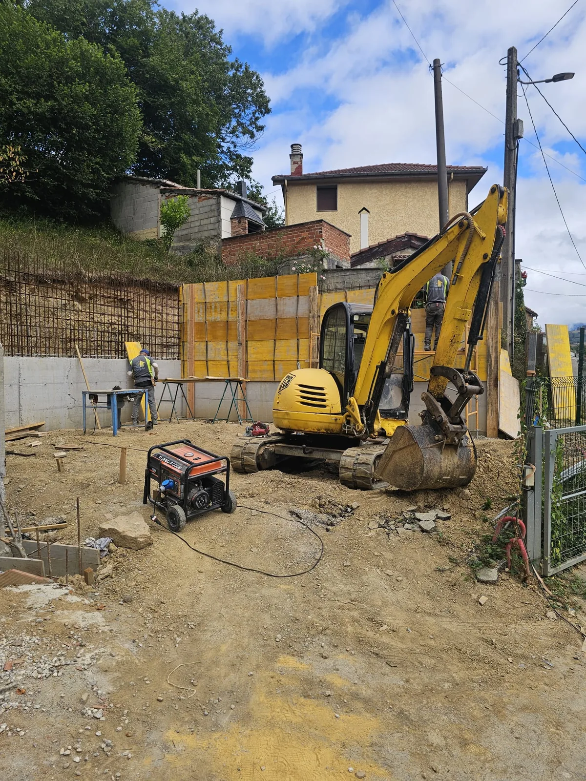 Ejecución de un muro de contención con excavación y maquinaria en una obra en Asturias.