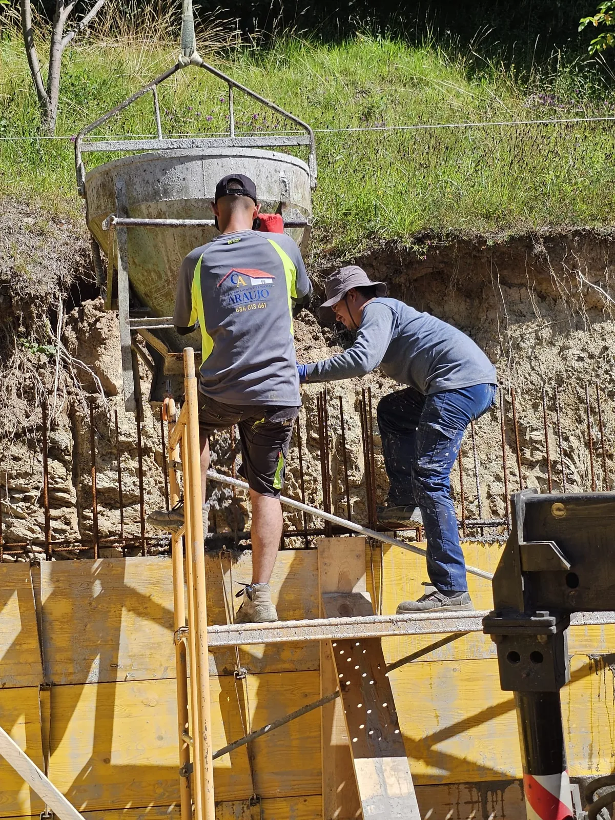 Operario de Construcciones Reformas Araujo hormigonando un muro de contención en Asturias.